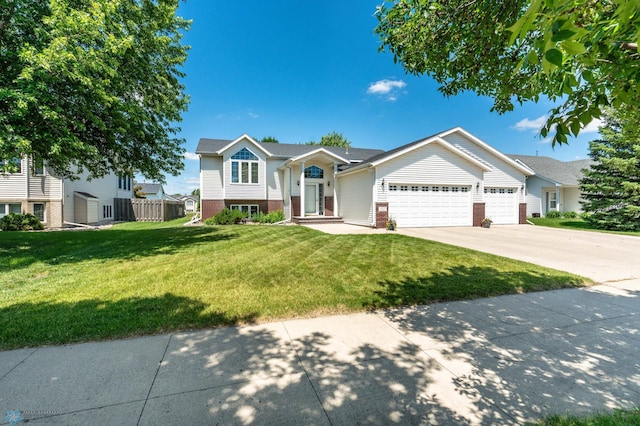 152 17th Ave W, West Fargo, ND 58078 - raised ranch featuring a garage, concrete driveway, a front yard, and brick siding