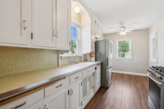 1215 Palace Ave, Saint Paul, MN 55105 - kitchen featuring appliances with stainless steel finishes, dark wood-style floors, white cabinets, backsplash, and a ceiling fan