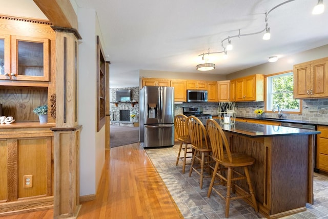 3170 Stark Rd, Fish Lake Twp, MN 55032 - kitchen with stainless steel appliances, dark countertops, a kitchen bar, and tasteful backsplash