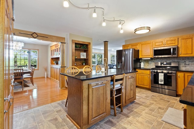 3170 Stark Rd, Fish Lake Twp, MN 55032 - kitchen with stainless steel appliances, a breakfast bar area, a kitchen island, tasteful backsplash, and a chandelier