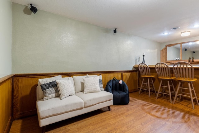 3170 Stark Rd, Fish Lake Twp, MN 55032 - living room with a bar, wood finished floors, wainscoting, and wooden walls
