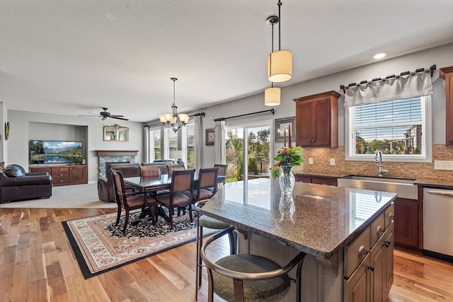 9871 7th St N, Lake Elmo, MN 55042 - kitchen with dishwasher, light wood-style flooring, open floor plan, backsplash, and a textured ceiling