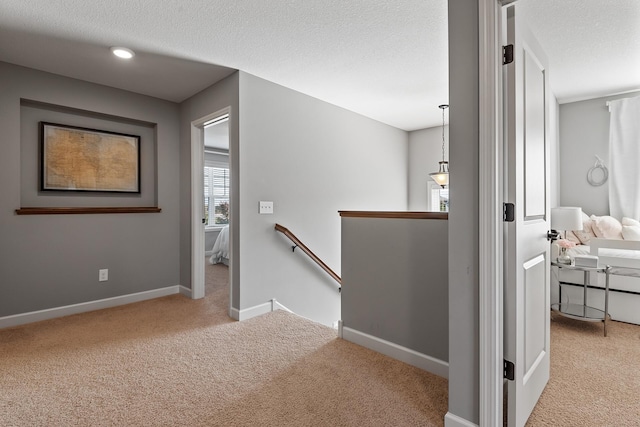 9871 7th St N, Lake Elmo, MN 55042 - hallway with an upstairs landing, carpet floors, and a textured ceiling
