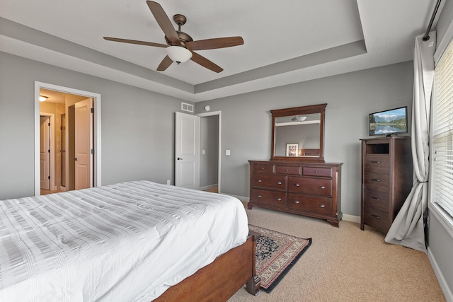 9871 7th St N, Lake Elmo, MN 55042 - bedroom featuring a tray ceiling, light colored carpet, and a ceiling fan