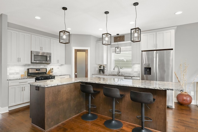 677 Sandstone Cir, Orono, MN 55356 - kitchen featuring stainless steel appliances, a center island, tasteful backsplash, dark wood-style floors, and recessed lighting