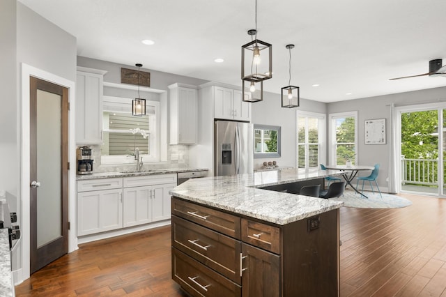 677 Sandstone Cir, Orono, MN 55356 - kitchen with appliances with stainless steel finishes, white cabinets, dark wood-style flooring, a center island, and recessed lighting