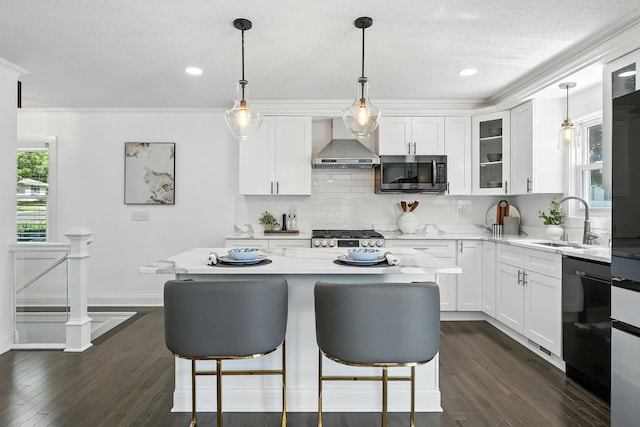 2638 Florida Ave S, Saint Louis Park, MN 55426 - kitchen featuring stainless steel appliances, wall chimney range hood, a breakfast bar area, tasteful backsplash, and white cabinets