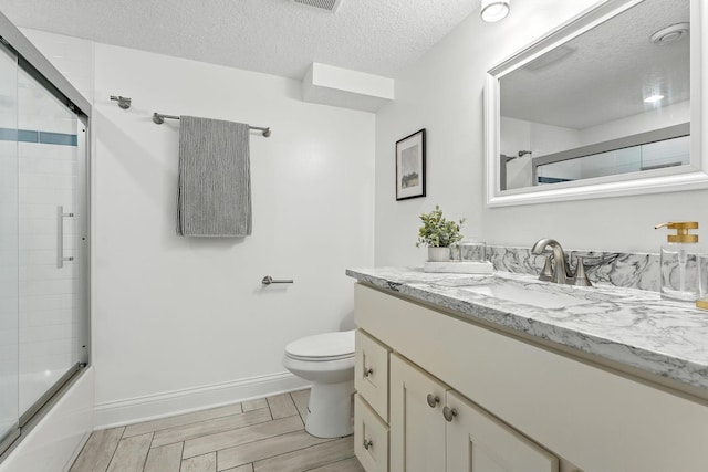 2638 Florida Ave S, Saint Louis Park, MN 55426 - full bathroom featuring vanity, wood finished floors, shower / bath combination with glass door, and a textured ceiling