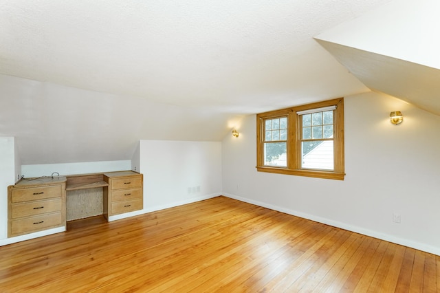 1007 12th Ave NE, Rochester, MN 55906 - additional living space with light wood-style flooring, vaulted ceiling, and built in study area