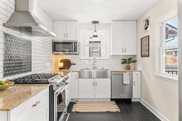3615 33rd Ave S, Minneapolis, MN 55406 - kitchen with stainless steel appliances, wall chimney exhaust hood, dark tile patterned floors, and white cabinets