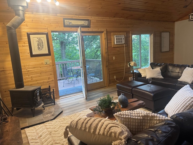 1952 75th Ave, Dresser, WI 54009 - living area with wood walls, a wood stove, an AC wall unit, light wood-type flooring, and vaulted ceiling