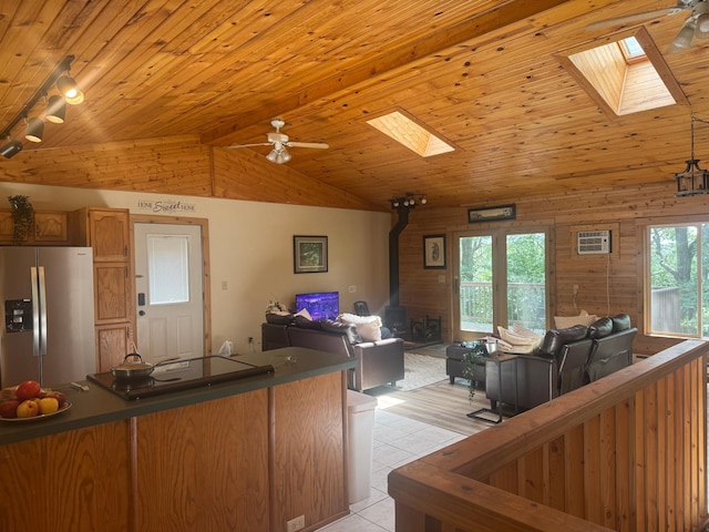 1952 75th Ave, Dresser, WI 54009 - kitchen featuring stainless steel fridge with ice dispenser, a skylight, a wood stove, open floor plan, and black electric cooktop