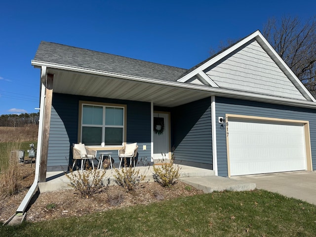 1817 Ridgewood Cir, Menomonie, WI 54751 - view of front of home with an attached garage, a porch, driveway, and a shingled roof