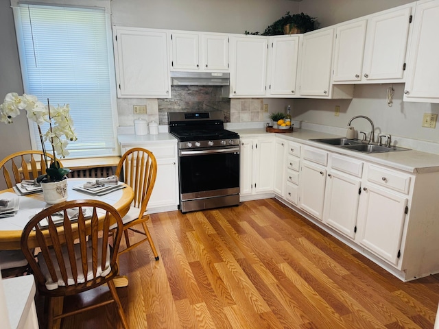 371 Sherburne Ave, Saint Paul, MN 55103 - kitchen featuring gas range, under cabinet range hood, white cabinetry, and light countertops