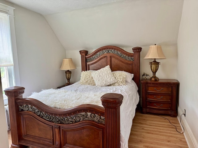 371 Sherburne Ave, Saint Paul, MN 55103 - bedroom with light wood-style flooring, lofted ceiling, and a textured ceiling