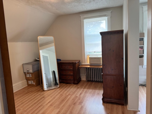 371 Sherburne Ave, Saint Paul, MN 55103 - additional living space featuring radiator heating unit, cooling unit, light wood-style floors, a textured ceiling, and vaulted ceiling