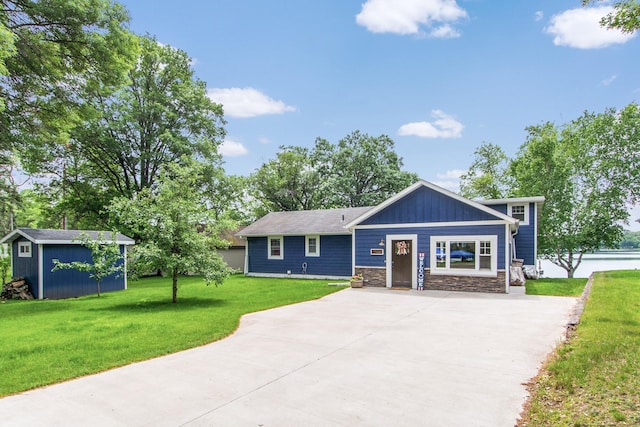 21865 512th Ln, Mcgregor, MN 55760 - view of front facade featuring concrete driveway, stone siding, a front yard, and a shed