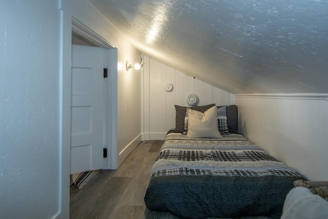 21865 512th Ln, Mcgregor, MN 55760 - bedroom featuring wood finished floors, lofted ceiling, a textured ceiling, and a textured wall