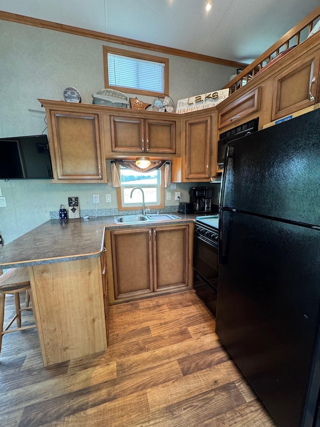 40716 Placid Dr, Dent, MN 56528 - kitchen with black appliances, ornamental molding, dark countertops, a peninsula, and light wood-style floors