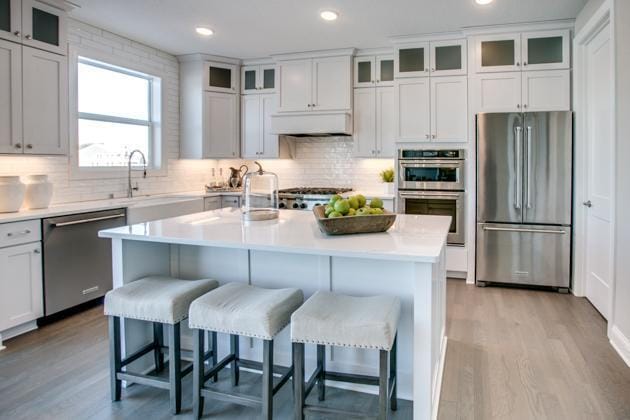 18210 102nd Pl N, Maple Grove, MN 55311 - kitchen featuring appliances with stainless steel finishes, light wood finished floors, backsplash, and recessed lighting