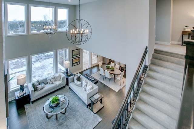 18210 102nd Pl N, Maple Grove, MN 55311 - living room featuring a chandelier, wood finished floors, a towering ceiling, and stairs