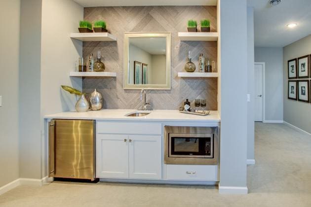18210 102nd Pl N, Maple Grove, MN 55311 - indoor wet bar with fridge, stainless steel microwave, decorative backsplash, and light colored carpet
