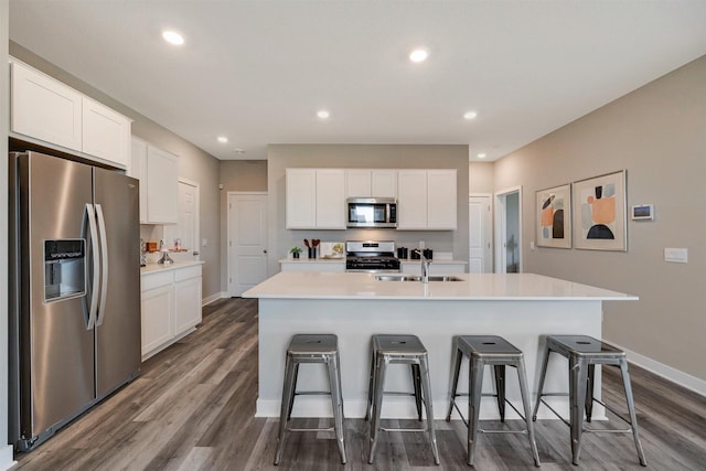 17021 Draper Way, Lakeville, MN 55044 - kitchen featuring stainless steel appliances, dark wood-type flooring, white cabinets, a kitchen breakfast bar, and light countertops