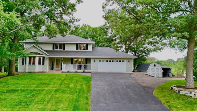 18224 Flanders St NE, East Bethel, MN 55092 - view of front of house featuring a porch, a front yard, asphalt driveway, a garage, and a shed