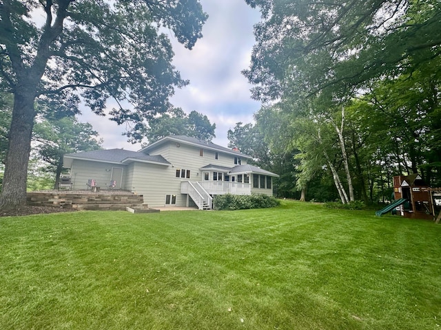 18224 Flanders St NE, East Bethel, MN 55092 - back of property with a playground, a sunroom, and a lawn