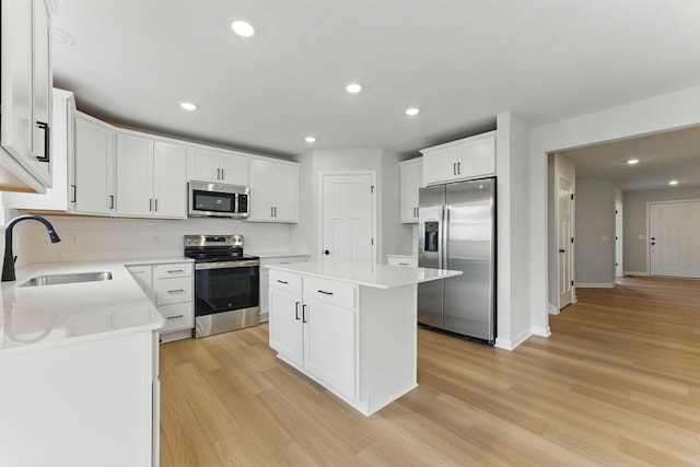 19391 Clearwater Loop, Farmington, MN 55024 - kitchen featuring stainless steel appliances, a kitchen island, light wood-type flooring, backsplash, and recessed lighting