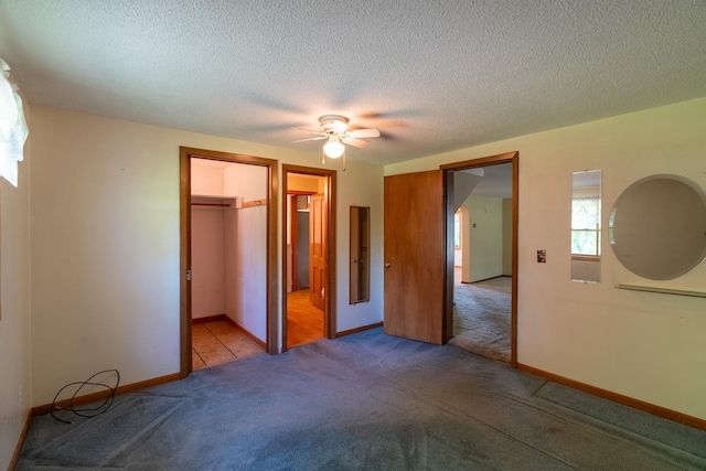 208 Lincoln St SW, Mapleton, MN 56065 - unfurnished bedroom featuring carpet, a closet, a spacious closet, a ceiling fan, and a textured ceiling