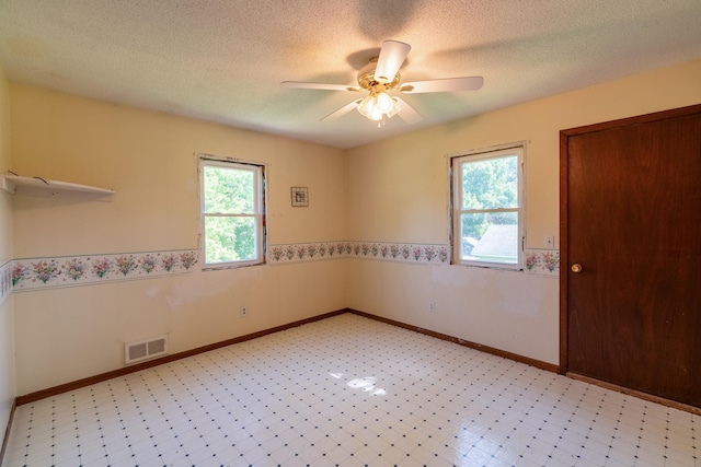 208 Lincoln St SW, Mapleton, MN 56065 - empty room featuring ceiling fan, a textured ceiling, and wainscoting