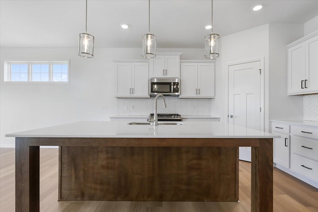 14990 144th Ave N, Dayton, MN 55327 - kitchen with stainless steel microwave, light countertops, decorative backsplash, wood finished floors, and white cabinets