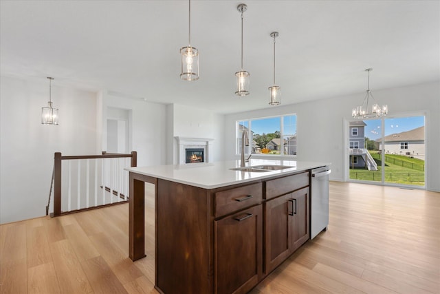 14990 144th Ave N, Dayton, MN 55327 - kitchen featuring dishwasher, light wood finished floors, light countertops, a glass covered fireplace, and a chandelier
