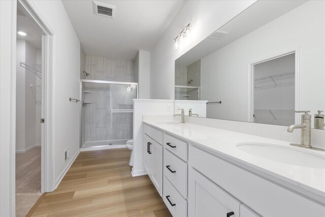 14990 144th Ave N, Dayton, MN 55327 - bathroom with a spacious closet, double vanity, a stall shower, and wood finished floors