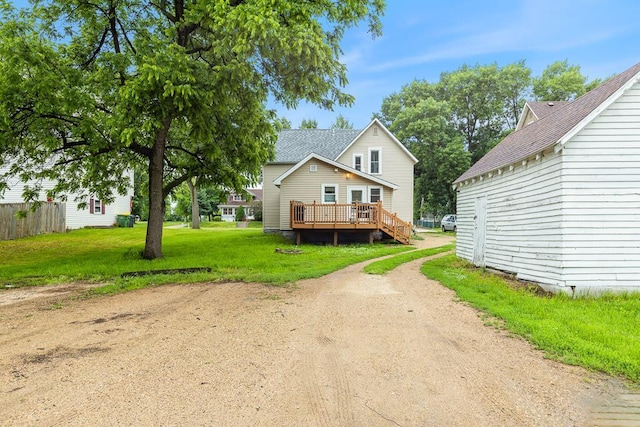205 Main St, Marshall, MN 56258 - traditional-style house with a wooden deck, driveway, a front lawn, and a shingled roof