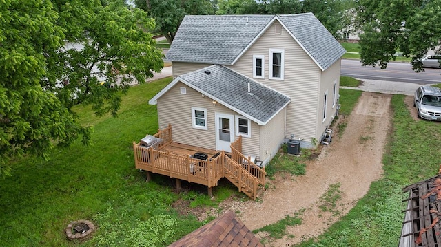 205 Main St, Marshall, MN 56258 - rear view of property featuring roof with shingles, a wooden deck, and a lawn