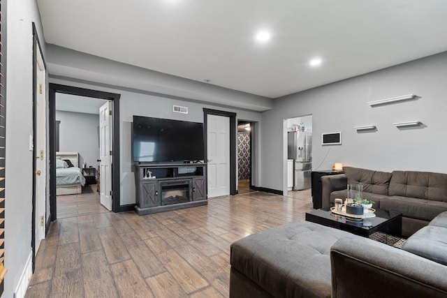 205 Main St, Marshall, MN 56258 - living room featuring wood finished floors, recessed lighting, and a glass covered fireplace