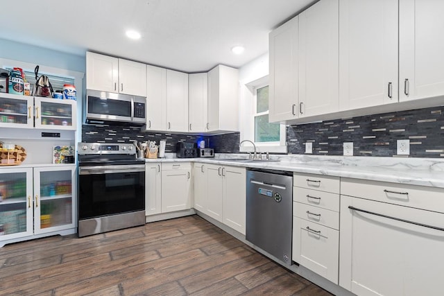 205 Main St, Marshall, MN 56258 - kitchen featuring stainless steel appliances, decorative backsplash, white cabinets, dark wood-style floors, and recessed lighting
