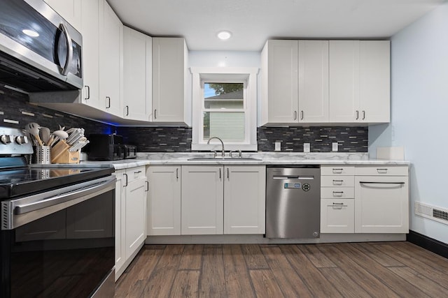 205 Main St, Marshall, MN 56258 - kitchen featuring appliances with stainless steel finishes, white cabinetry, tasteful backsplash, and recessed lighting