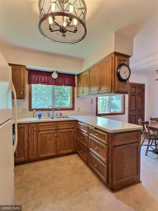 320 Ramey Rd, Maple Lake, MN 55358 - kitchen featuring freestanding refrigerator, a peninsula, light colored carpet, brown cabinets, and light countertops