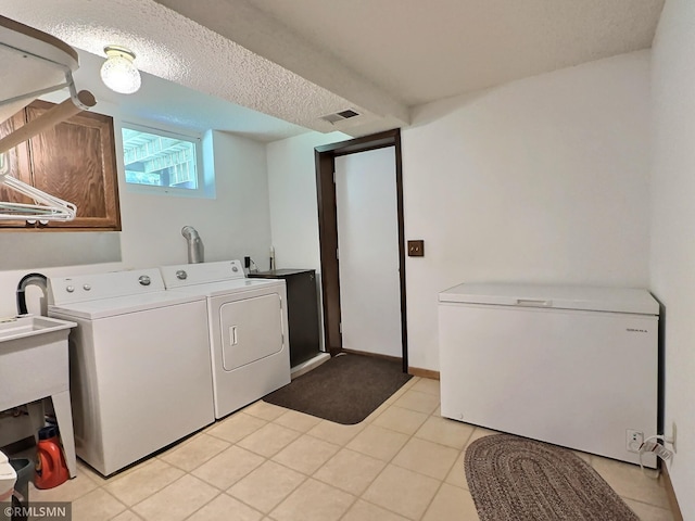 320 Ramey Rd, Maple Lake, MN 55358 - laundry room featuring washing machine and dryer, light tile patterned floors, and a textured ceiling