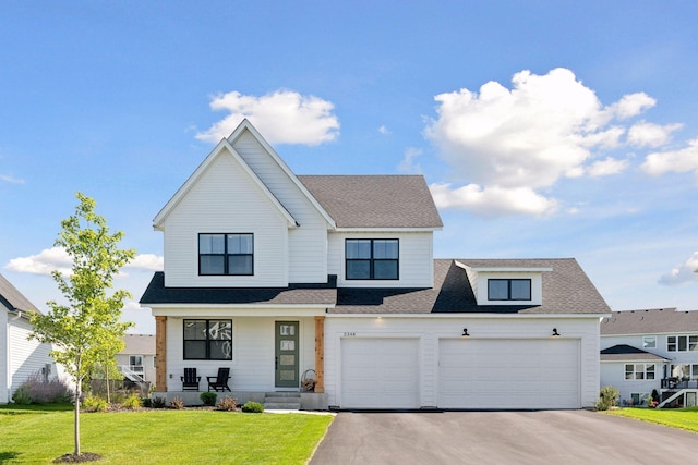 2348 Kester Ave NE, Saint Michael, MN 55376 - view of front facade with asphalt driveway, covered porch, a front lawn, a shingled roof, and a garage