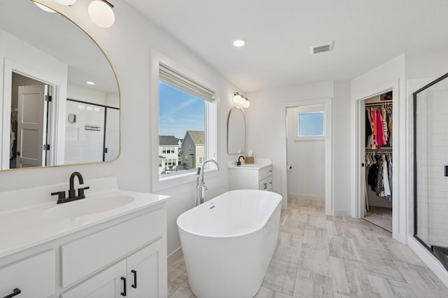 2348 Kester Ave NE, Saint Michael, MN 55376 - full bathroom with a stall shower, vanity, a spacious closet, a freestanding tub, and recessed lighting