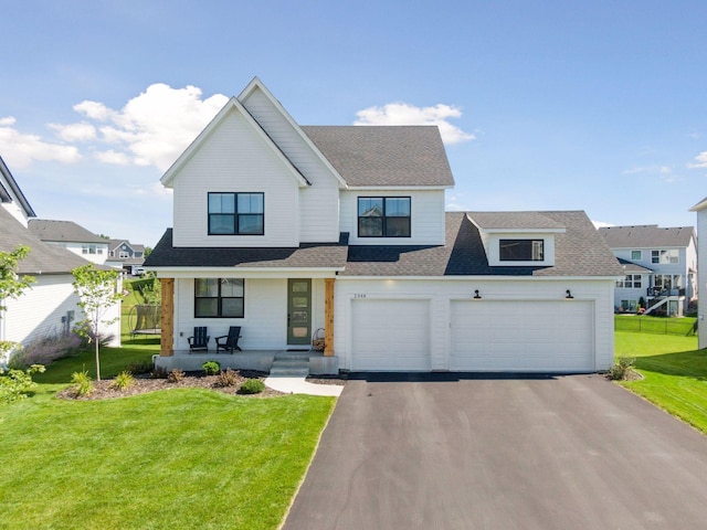2348 Kester Ave NE, Saint Michael, MN 55376 - view of front facade with a porch, driveway, a shingled roof, a front yard, and an attached garage