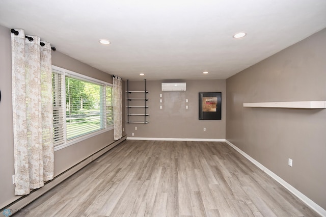 1253 3rd St N, Fargo, ND 58102 - spare room with a baseboard heating unit, a wall unit AC, wood finished floors, and recessed lighting