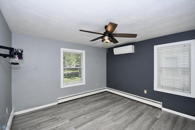 1253 3rd St N, Fargo, ND 58102 - spare room featuring a wall mounted air conditioner, baseboard heating, wood finished floors, and a ceiling fan