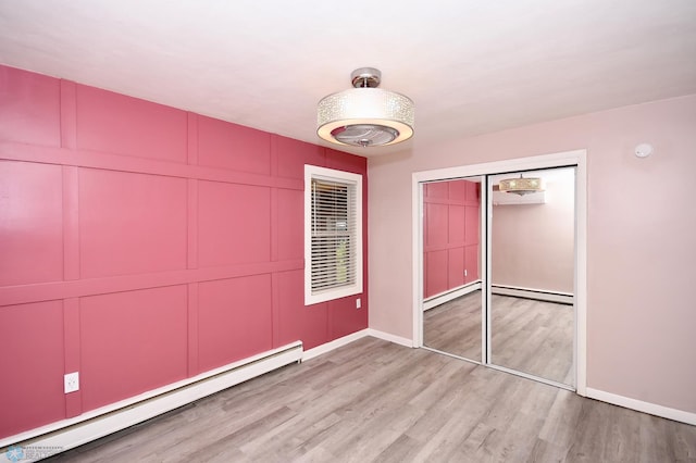 1253 3rd St N, Fargo, ND 58102 - unfurnished bedroom featuring a baseboard heating unit and light wood-style flooring