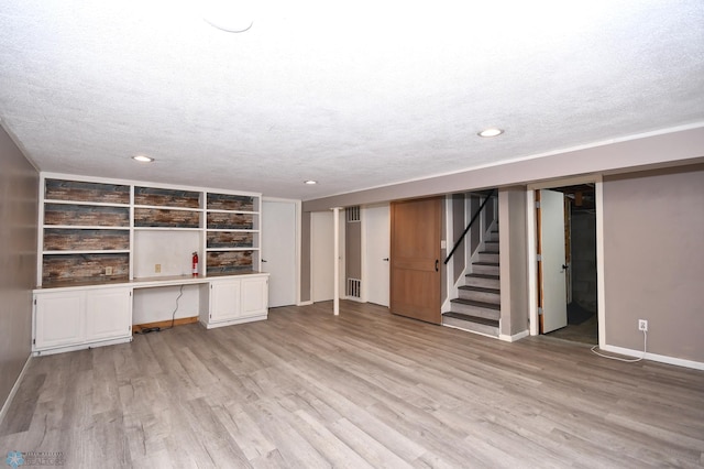 1253 3rd St N, Fargo, ND 58102 - unfurnished living room with light wood-style flooring, a textured ceiling, stairs, and recessed lighting