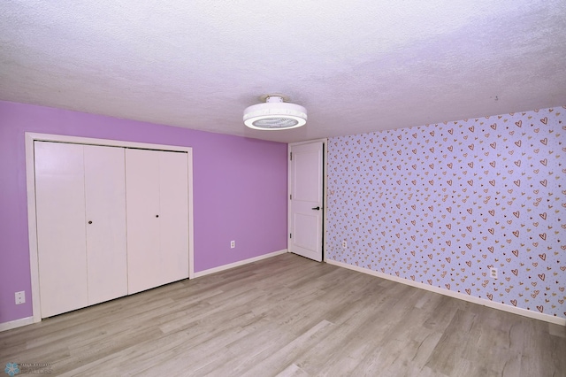 1253 3rd St N, Fargo, ND 58102 - unfurnished bedroom with wood finished floors, a textured ceiling, and a closet